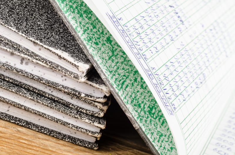 Old bookkeeping ledger books, the top one open showing columns of numbers