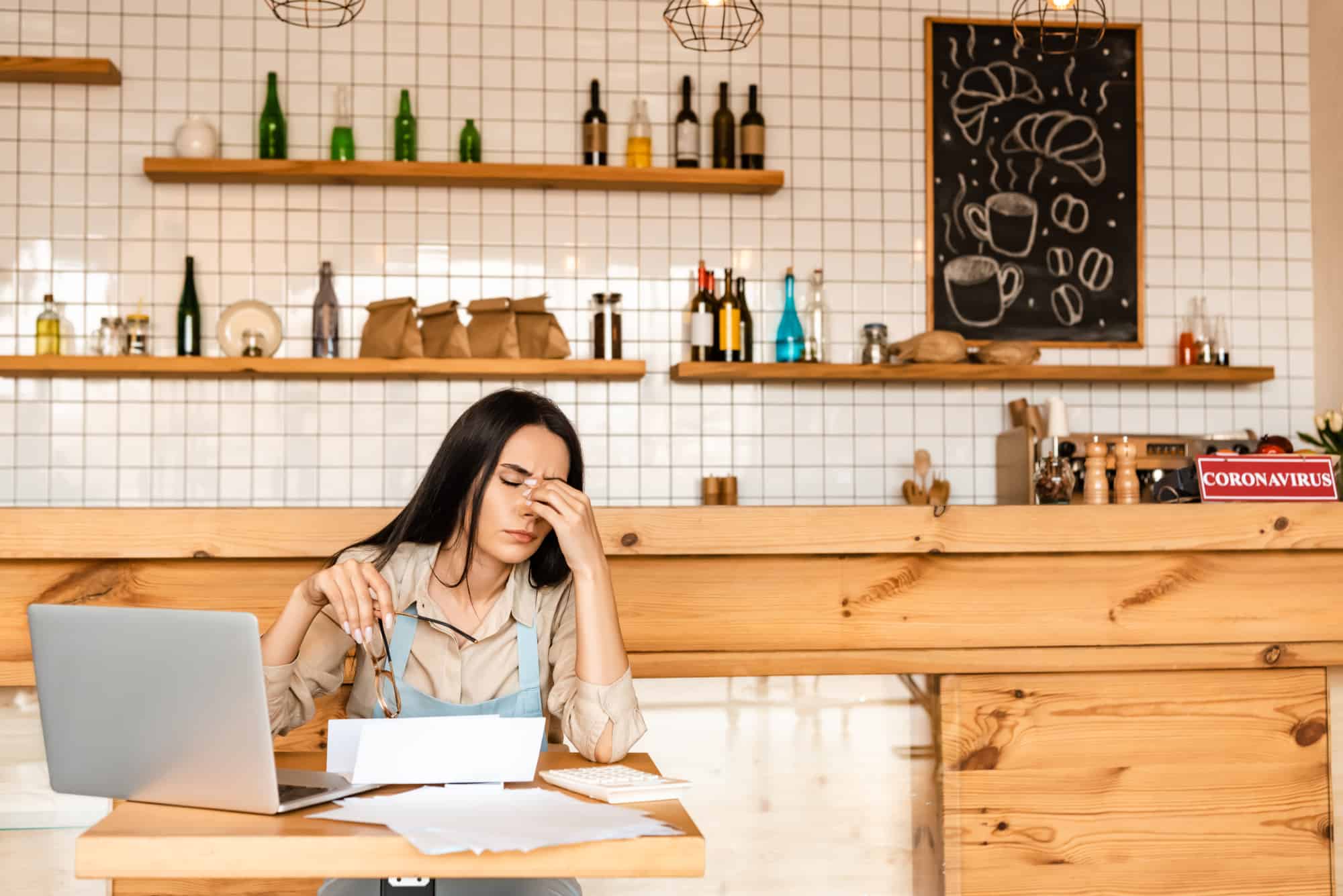 Exhausted female business owner doing closing work for her café.